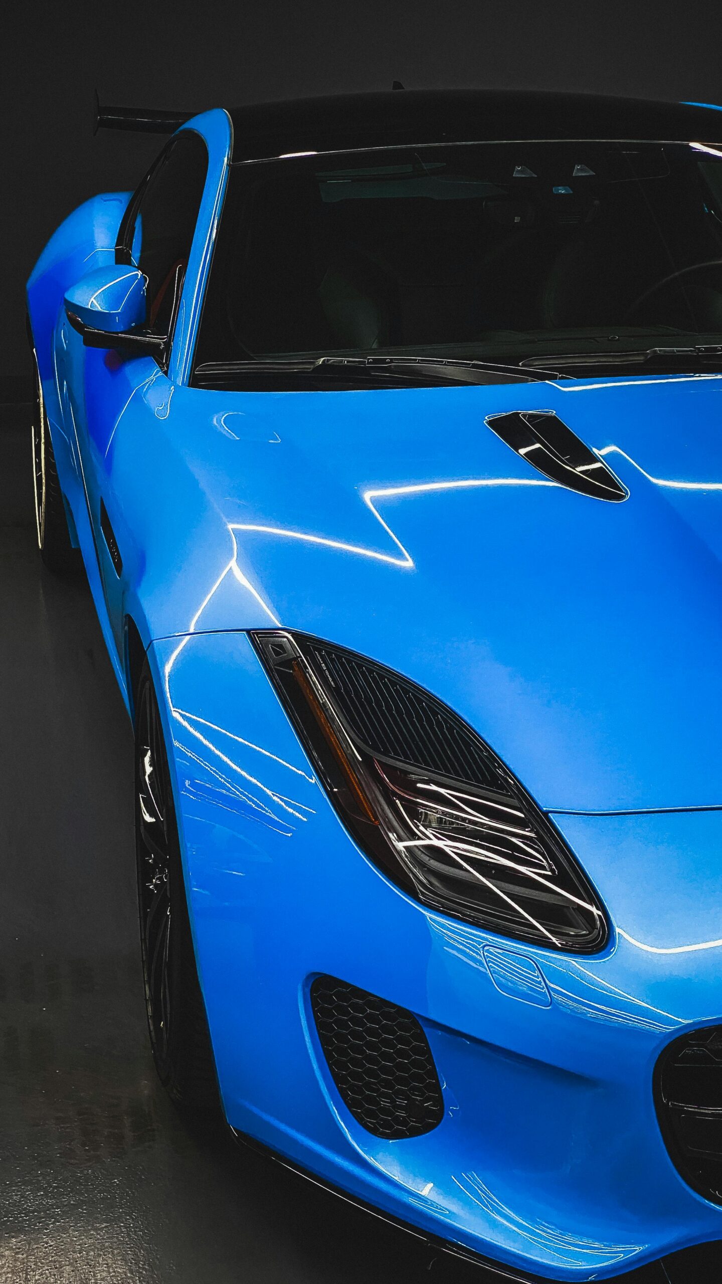 Sleek blue sports car showcased in a modern Dubai showroom, highlighting elegant design.